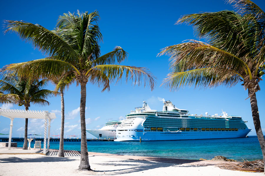 Royal Caribbean cruise ship docked at a tropical island with vibrant turquoise waters