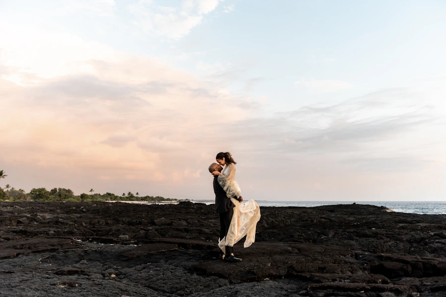 Newlyweds sharing a romantic moment on a coastal cliff
