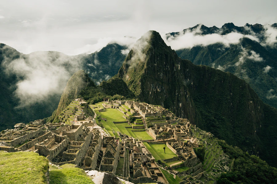 Ancient ruins of Machu Picchu with mountain peaks and clouds
